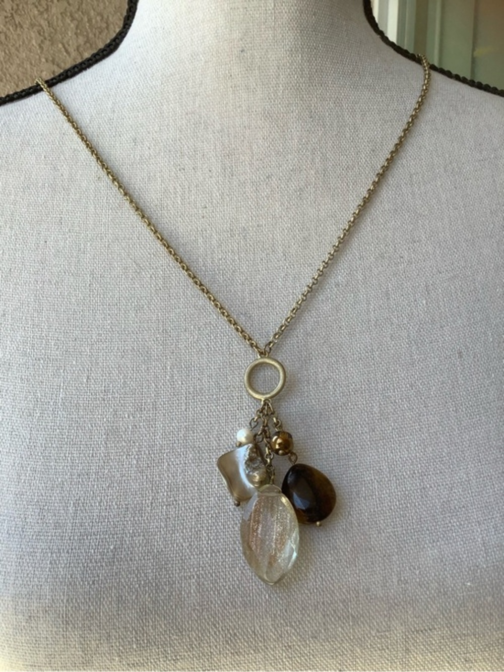 Gold Tone fashion necklace with a cluster of charms